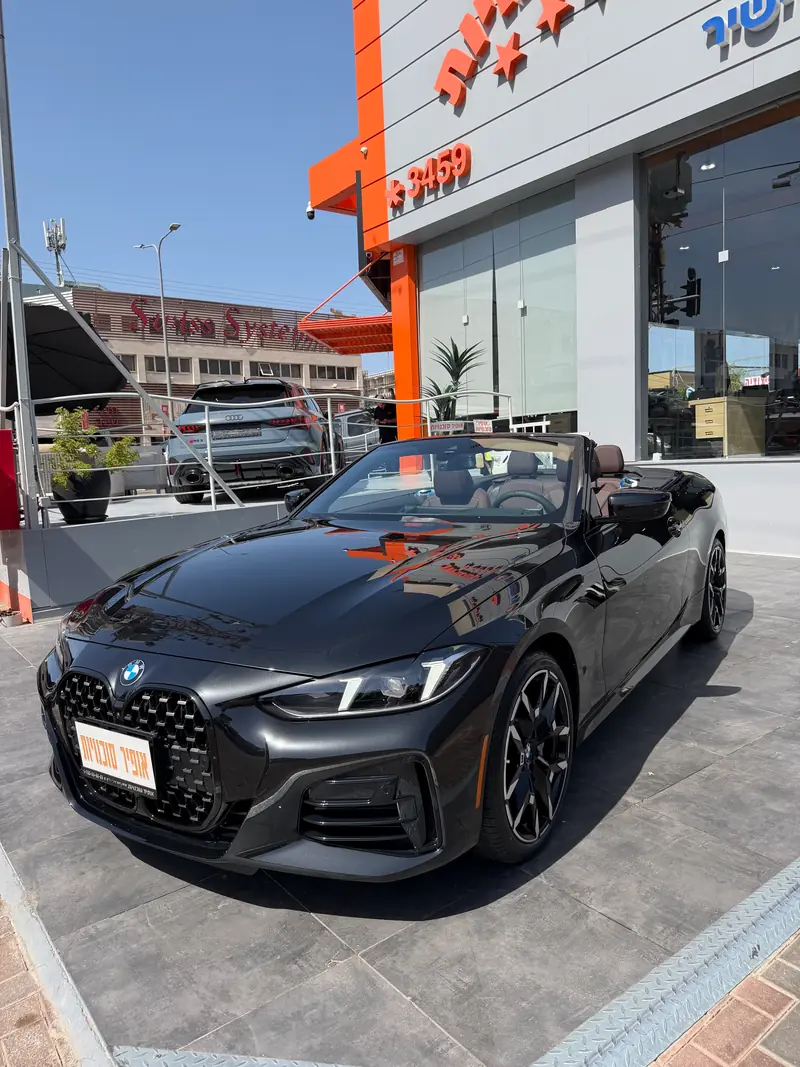 ב.מ.וו 430i קבריולט שחורה עם גג פתוח מול הבניין